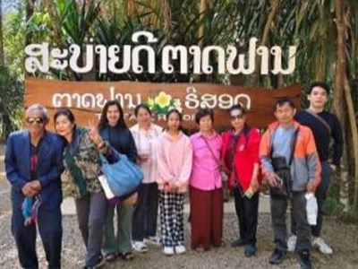 คณะลูกค้าถ่ายรูปหมู่หน้าป้ายน้ำตกตาดฟาน สปป.ลาว